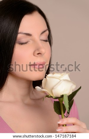 Women smelling the flower aroma. Portrait of beautiful middle-aged women smelling the white rose