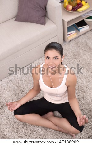 Home yoga. Top view of beautiful young women meditating at home while sitting in a lotus position