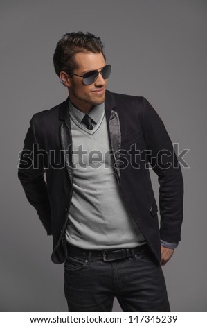 Taking It Easy. Handsome Young Men Posing With His Hands In Pockets And Looking Away While Standing Isolated On Grey
