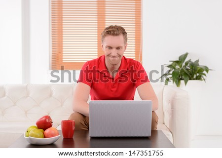 Men surfing web. Handsome young men sitting on the couch and using computer