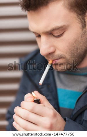 Getting a light. Close-up of men getting a light while holding a cigarette in his mouth