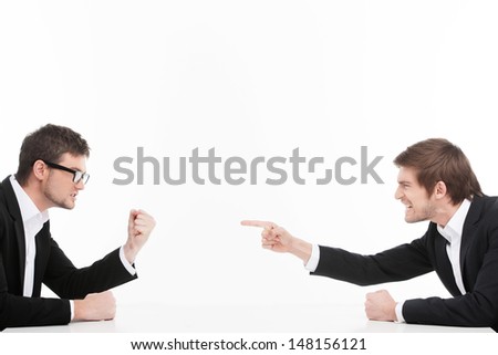 Men's confrontation. Two angry young business people shouting and blaming each other while isolated on white - stock photo