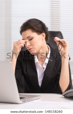 Tired Businesswoman. Tired Middle-Aged Businesswoman Sitting At Her Working And Keeping Her Eyes Closed