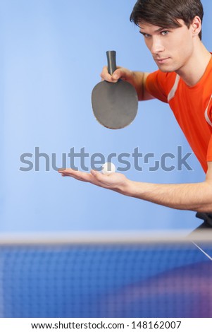Serving a ball. Confident young men playing table tennis