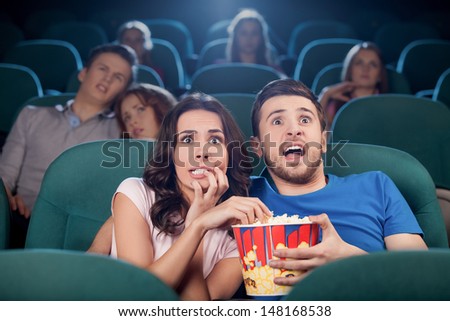 Couple Watching Horror Movie. Terrified People In Watching Movie At The Cinema