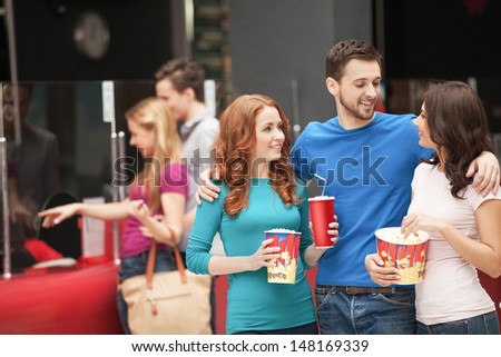 Friends at the cinema. Cheerful young people talking at the cinema hall