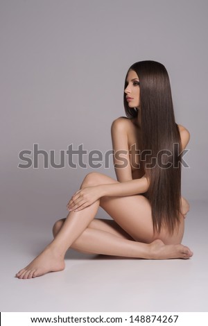 Long hair beauty Attractive naked women with beautiful hair sitting on the floor and looking away while isolated on white Long hair beauty Attractive naked women with beautiful hair sitting on the floor and looking away while isolated on white