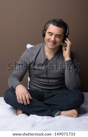 Man listening to the music. Relaxed middle-aged man listening to the music while sitting on the sofa