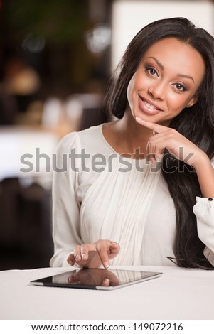 Woman with digital tablet. Beautiful African descent women working on digital tablet and smiling