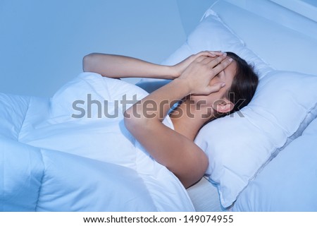 Depressed women in bed. Top view of young sad women lying on the sofa and hiding her face in hands