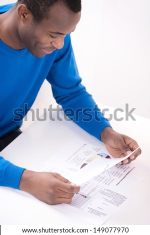 Paperwork. Top view of cheerful African descent men reading paper