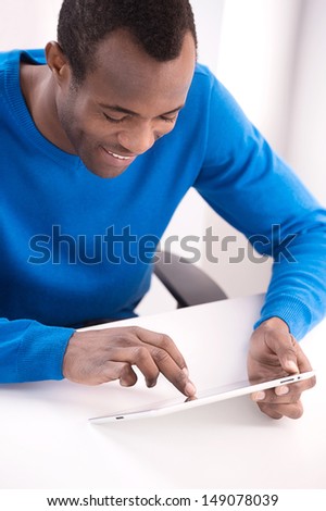 Working at the digital tablet. Top view of cheerful African descent men Working at the digital tablet