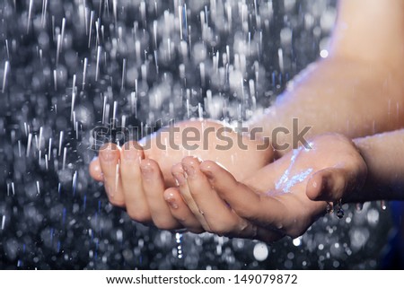 Falling water. Close-up of water falling on human hands