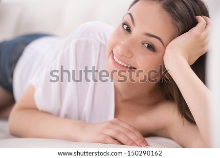 Just relaxing. Beautiful young cheerful woman relaxing on the couch