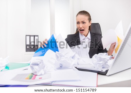 Mess on the working place. Shocked woman looking at the mess on her working place