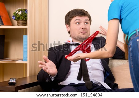 Busted. Man in formal wear gesturing while his girlfriend showing red panties to him