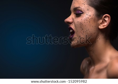 Beautiful woman grimacing. Side view of beautiful young girl making a face while isolated on colored background