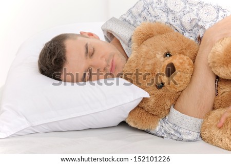 Big baby with Teddy Bear. Infant adult man sleeping with his teddy bear