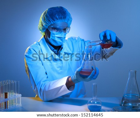 Scientific experiment. Confident young man in protective work wear making scientific experiment while isolated on white