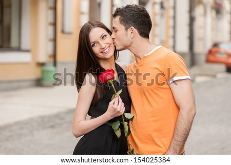 Kiss. Cheerful Young Couple Hugging While Man Kissing His Girlfriend In Cheek