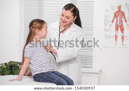 Doctor and little girl. Cheerful young doctor in lab coat examining little girl