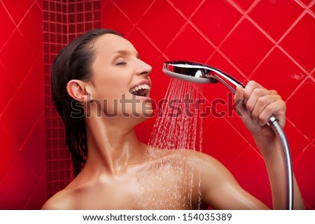 Singing in shower. Beautiful young woman taking shower and singing