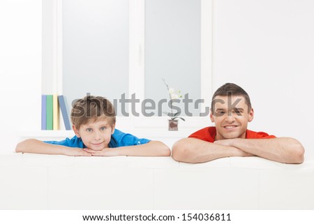 Cheerful father and son. Cheerful father and son looking at camera and smiling