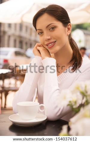 Women in restaurant. Beautiful young women looking at camera and smiling while sitting at the restaurant