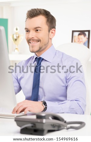 Businessman at work. Confident young man in formalwear working at the computer while sitting at his working place