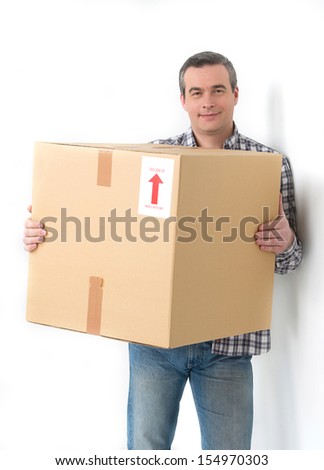 House moving. Cheerful middle-aged man holding cardboard box and smiling