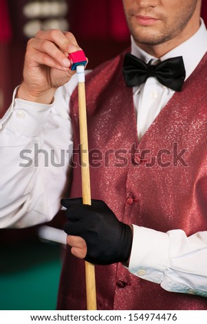Pool player. Cropped image of confident young pool player holding cue
