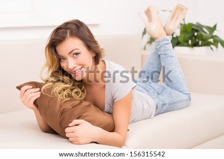 Woman on the couch. Beautiful young women lying on the couch and smiling