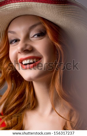 Red hair beauty. Portrait of beautiful young red hair woman in hat smiling at camera