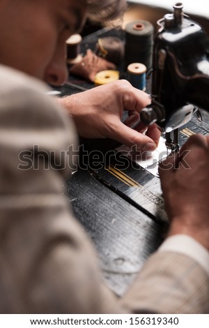 Tailor At Work. Top View Of Confident Young Tailor Working At The Tailor Shop