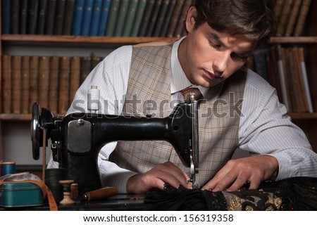 Tailor at work. Confident young man working at the tailor shop