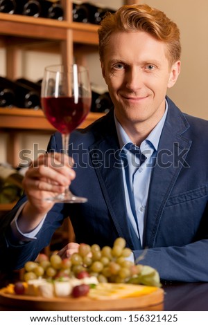 Man with wine glass. Handsome young man holding a wine glass and smiling