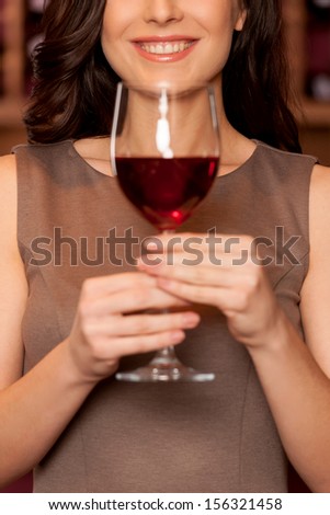 Woman with wine glass. Cropped image of beautiful young woman holding wine glass and smiling