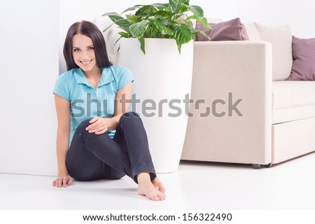 Beauty at home. Beautiful young woman sitting on the floor at home