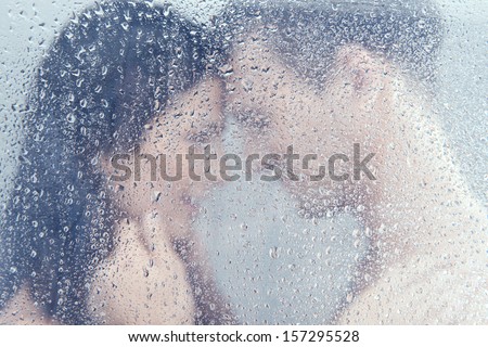 Loving couple in shower. Beautiful young loving couple hugging while standing in shower