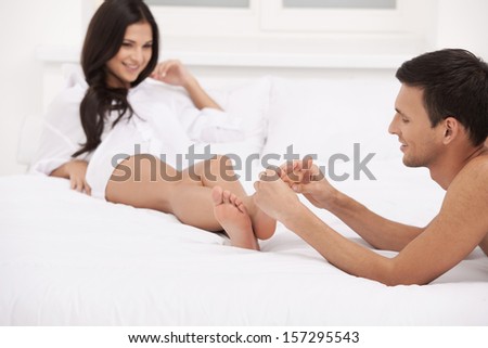 Loving couple. Handsome young man making massage for his girlfriend