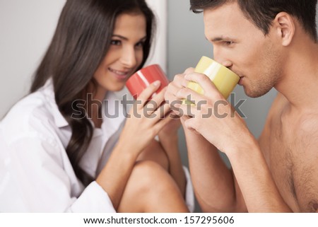 Loving couple. Beautiful young loving couple looking at each other and drinking coffee