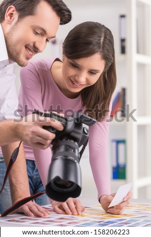 Photographer Is Showing To Editor Photos On Camera. Close Up Of Two Smiling People