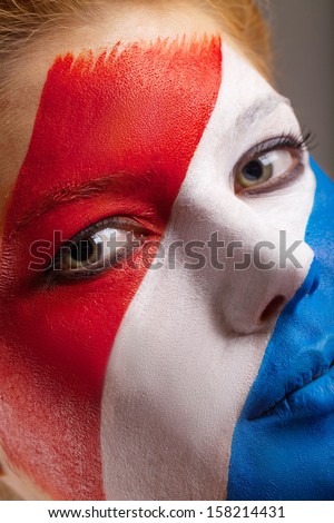 Close up of face art. Netherlands flag is painted on woman face