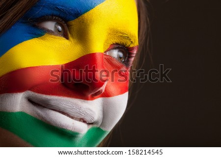 Face art. Face painted with Ukrainian and Italian flags on it