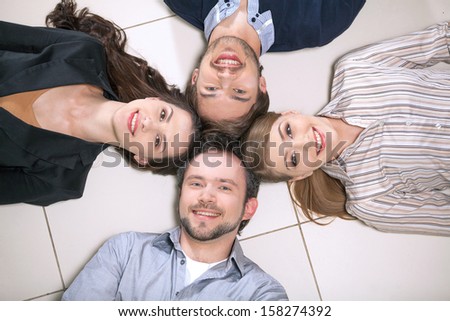 Top view of people laying together. Smiling holding heads together
