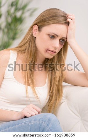 Portrait of thoughtful woman with bruise on her face. Looking away with sad look