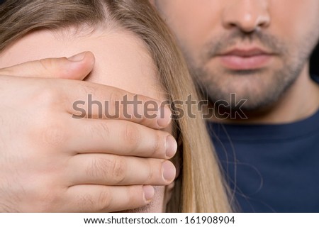 Close up of man and woman. Man closing female yes with his hand