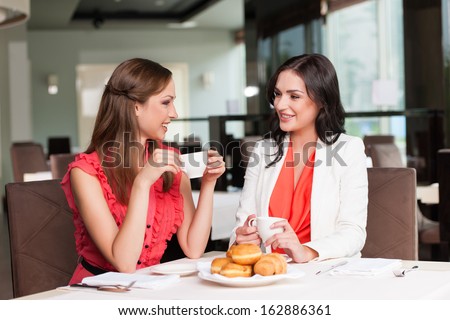 Two Girlfriends Meet At Cafã?Â?Ã?Â© For Breakfast. Talking And Gossiping