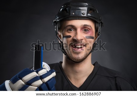 Funny hockey player smiling with one tooth missing. Isolated on black