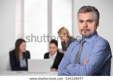 Portrait of Successful confident business man standing. Group of business people on blur background